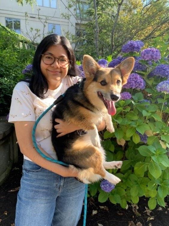 Volunteer Briana with her dog standing in a garden